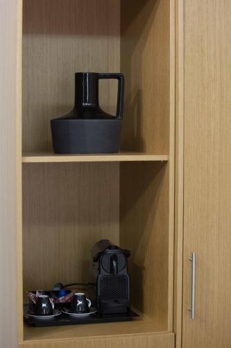 a cupboard with a tea kettle and bowls on it at Alexandros in Giannitsa