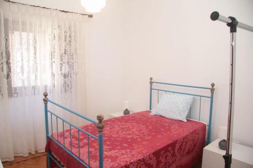 a bedroom with a bed with a red bedspread at Vivenda Maria da Nazaré in Picamilho