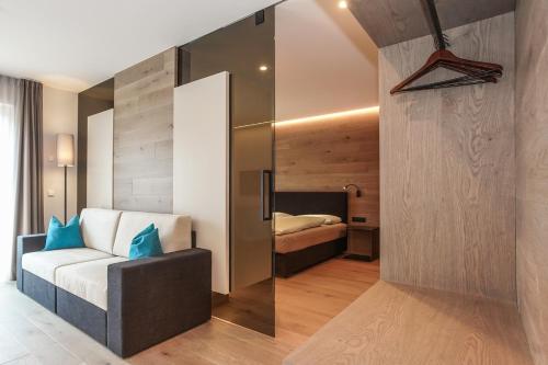 a bedroom with a bed and a couch in a room at Gasthof Sonne snc in Sarntal