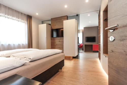 a bedroom with two beds and a living room at Gasthof Sonne snc in Sarntal