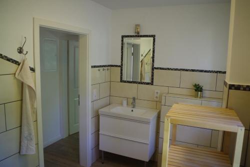 a bathroom with a sink and a mirror at Rüthlis Hüs in Klanxbüll