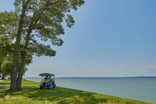 a golf cart on the grass near the water at Grey's Point Camp Cottage 7 in Locklies