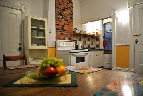a kitchen with a bowl of fruit on a table at Vancouver Hideaway Guesthouse in Vancouver