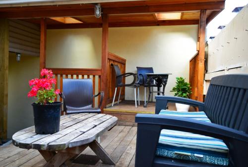 a porch with a wooden bench and chairs and a table at Vancouver Hideaway Guesthouse in Vancouver