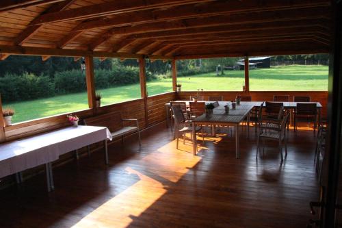 a dining room with tables and chairs and a large window at Penzion Sileo in Pribylina