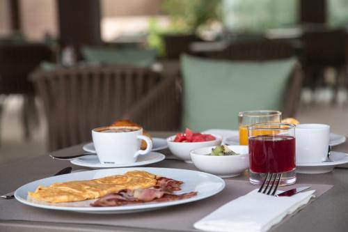 una mesa con una bandeja de comida y café para el desayuno en Sa Pedrera Suites & Spa, en Es Pujols