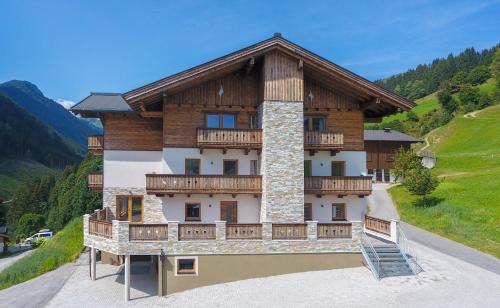 uma casa com uma varanda numa montanha em Appartement Berghof em Saalbach-Hinterglemm