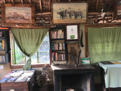 a room with a fireplace and book shelves with books at Maasai Simba Camp in Amboseli
