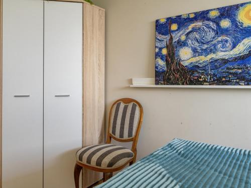 um quarto com uma cama, uma cadeira e um quadro em Apartament Chmielna 35 em Varósvia