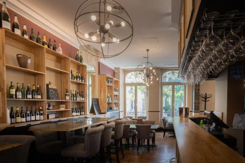 eine Bar in einem Restaurant mit einem langen Tisch und Stühlen in der Unterkunft La Cave de l'Avenue de champagne in Épernay