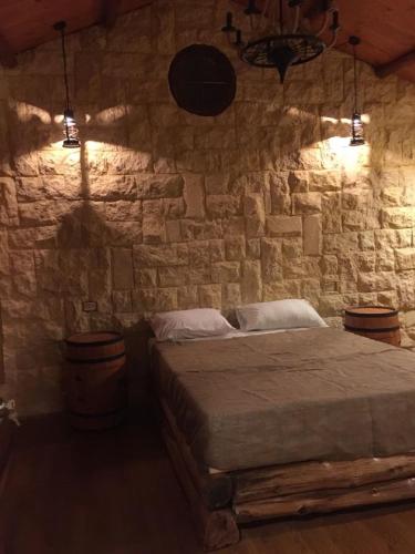 a bedroom with a stone wall with a bed at Jasmin Holiday House in Alexandria