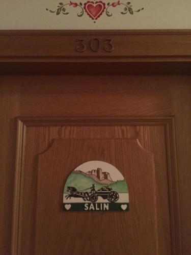 a wooden door with a sign on it at Hotel Garni Soreie in Pozza di Fassa