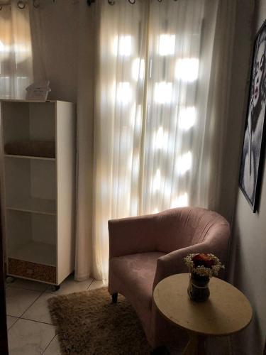 a living room with a couch and a table at Pousada Santa Lolla in São Carlos