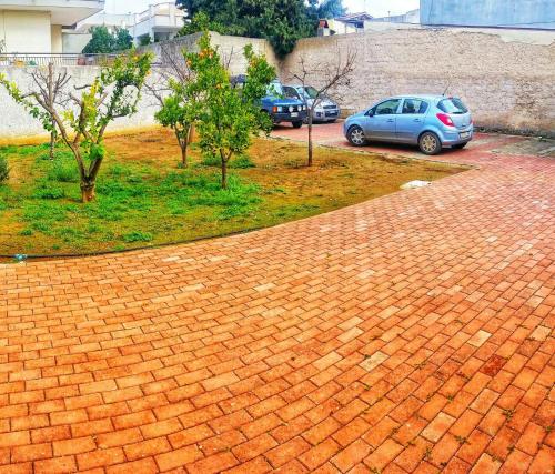 a brick driveway with cars parked in a parking lot at "Il Giardino Di Niu" in Palombaro