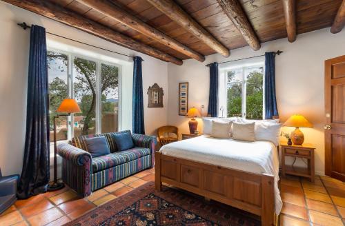 a bedroom with a bed and a couch at Inn of the Turquoise Bear in Santa Fe
