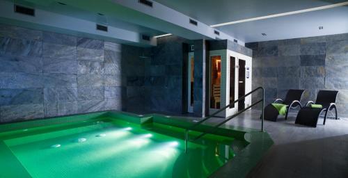 einen Pool in einem Zimmer mit einem Haus in der Unterkunft Montis Hotel & Spa in Poniatowa