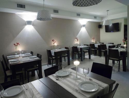 a dining room with tables and chairs and lights at Montis Hotel & Spa in Poniatowa