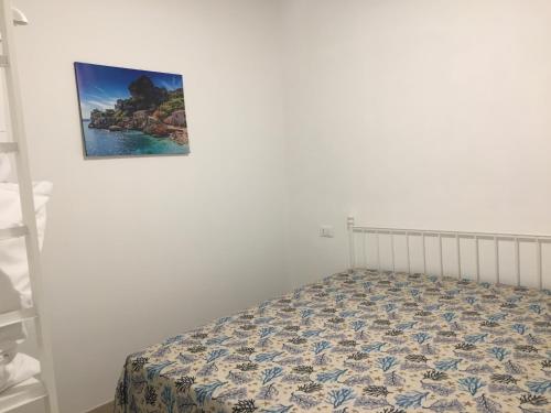 łóżko w pokoju ze zdjęciem na ścianie w obiekcie Casa Vacanze Mannina w mieście Castellammare del Golfo