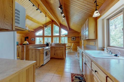 a large kitchen with wooden cabinets and a large window at Twin Pines Cabin in Estes Park
