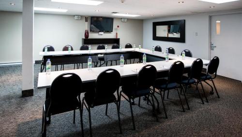 a meeting room with a long table and chairs at Hotel V in Gatineau