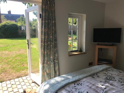 a bedroom with a bed and a sliding glass door at Corner House Luxury BnB in Little Dunmow
