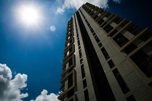 a tall building with the sun in the sky at Amazing sea View, steps to beach, near Tel-aviv in Bat Yam