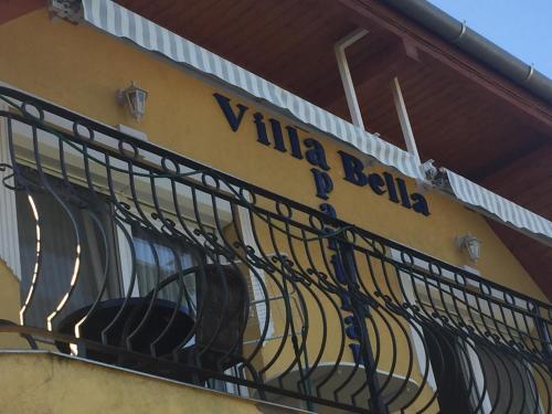 a balcony of a building with a sign on it at Villa Bella Apartman in Bük
