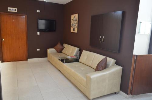 uma sala de estar com um sofá e uma televisão em Hotel Plaza Cúcuta Center em Cúcuta
