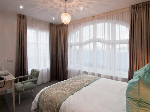 a bedroom with a bed and a desk and a window at W12 Rooms in London