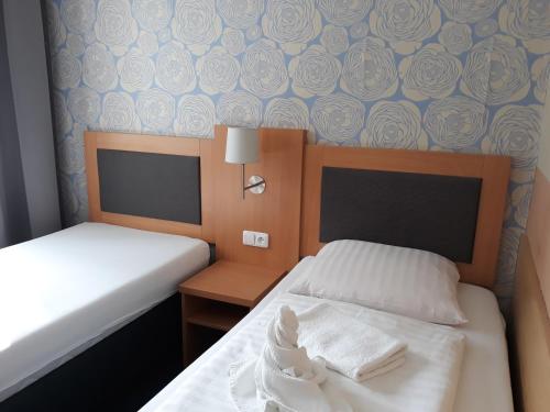 a bedroom with two beds and a wall with roses at Hotel Rozvoj in Klatovy