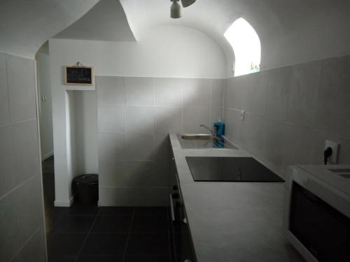 ein weißes Bad mit einem Waschbecken und einem Fenster in der Unterkunft Fisherman's Inn in Montijo