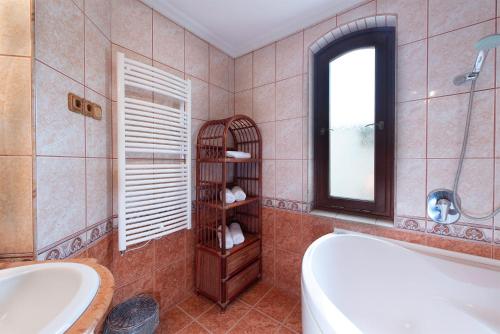 a bathroom with a tub and a sink and a mirror at Hajdu Apartman 2. in Hajdúszoboszló
