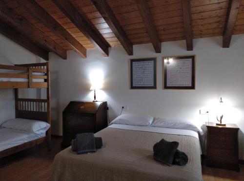 a bedroom with two beds and a dresser and two bunk beds at La Borda de Sort in Sort