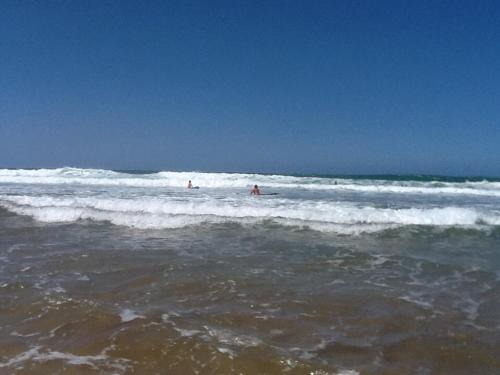 a group of people in the waves in the ocean at Sultana larache in Larache