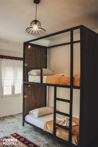 two bunk beds in a room with a chandelier at Friends' Guesthouse & Hostel in Gjirokastër