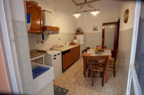 a small kitchen with a table and a table and chairs at Casa della nonna in Riposto