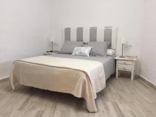 フエンヒロラにあるLa Casa de la Higueritaの白いベッドルーム(大型ベッド1台、ランプ2つ付)