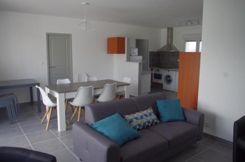 una sala de estar con un sofá y una mesa en La Maison Oceane, en Dolus d'Oléron