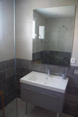une salle de bain avec un lavabo et un miroir dans l'établissement La Maison Oceane, à Dolus-d'Oléron