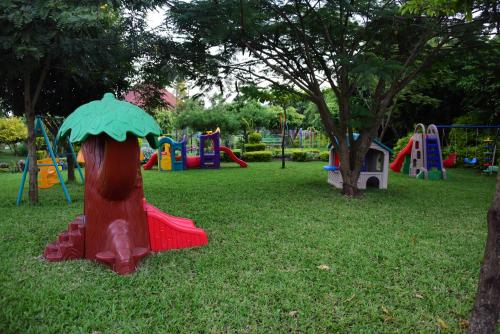 a park with playground equipment in the grass at Fun Retreat Resort, Hotel and Ayurveda Spa in Arusha