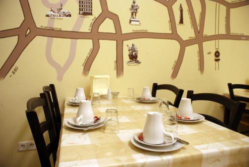 una mesa con sillas y una mesa larga con platos y servilletas en Hostel No 5, en Halle an der Saale