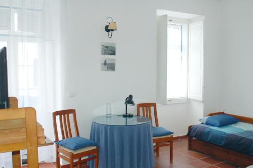 ペニシェにあるCasa da Luzのテーブル、椅子、ベッドが備わる客室です。