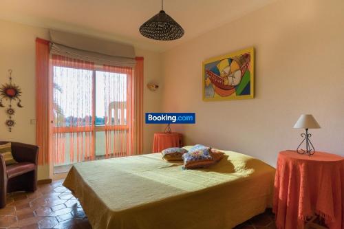 ポルシェスにあるAldeamento Vilamar - T2 completoのベッドルーム1室(ベッド1台、テーブル、窓付)