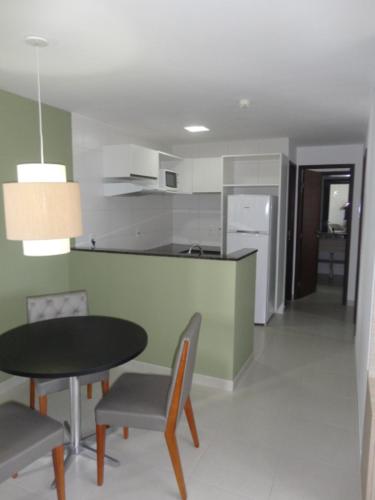 cocina y comedor con mesa y sillas en Flat Boa Viagem Premium 2qtos, en Recife