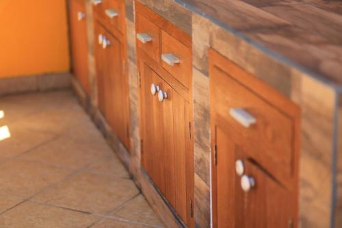 a row of wooden cabinets in a kitchen at Trojan House in Ensenada