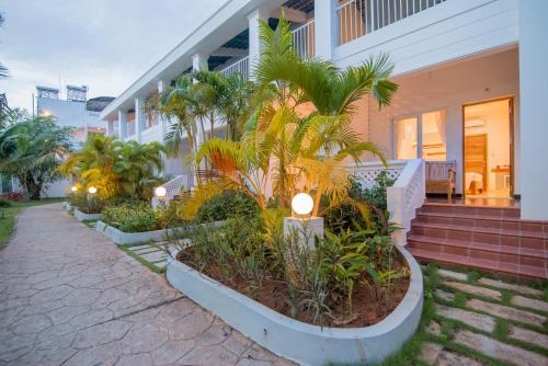 a house with palm trees in front of it at Palma Resort Phu Quoc, Trademark Collection by Wyndham in Phú Quốc