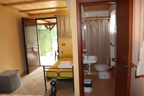 a bathroom with a bed and a sink and a toilet at Agriturismo Ghiritina in Francavilla di Sicilia