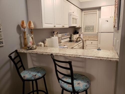 a kitchen with two chairs at a counter with a counter top at Hilton Head Resort in Hilton Head Island