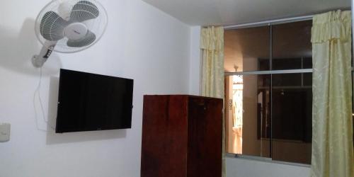 a living room with a television and a fan at BACHÍG Hospedaje in Moyobamba