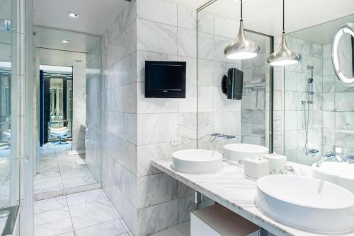ein Bad mit 2 Waschbecken und einem TV an der Wand in der Unterkunft Palms Place One Bedroom Suite 1220 sqft in Las Vegas